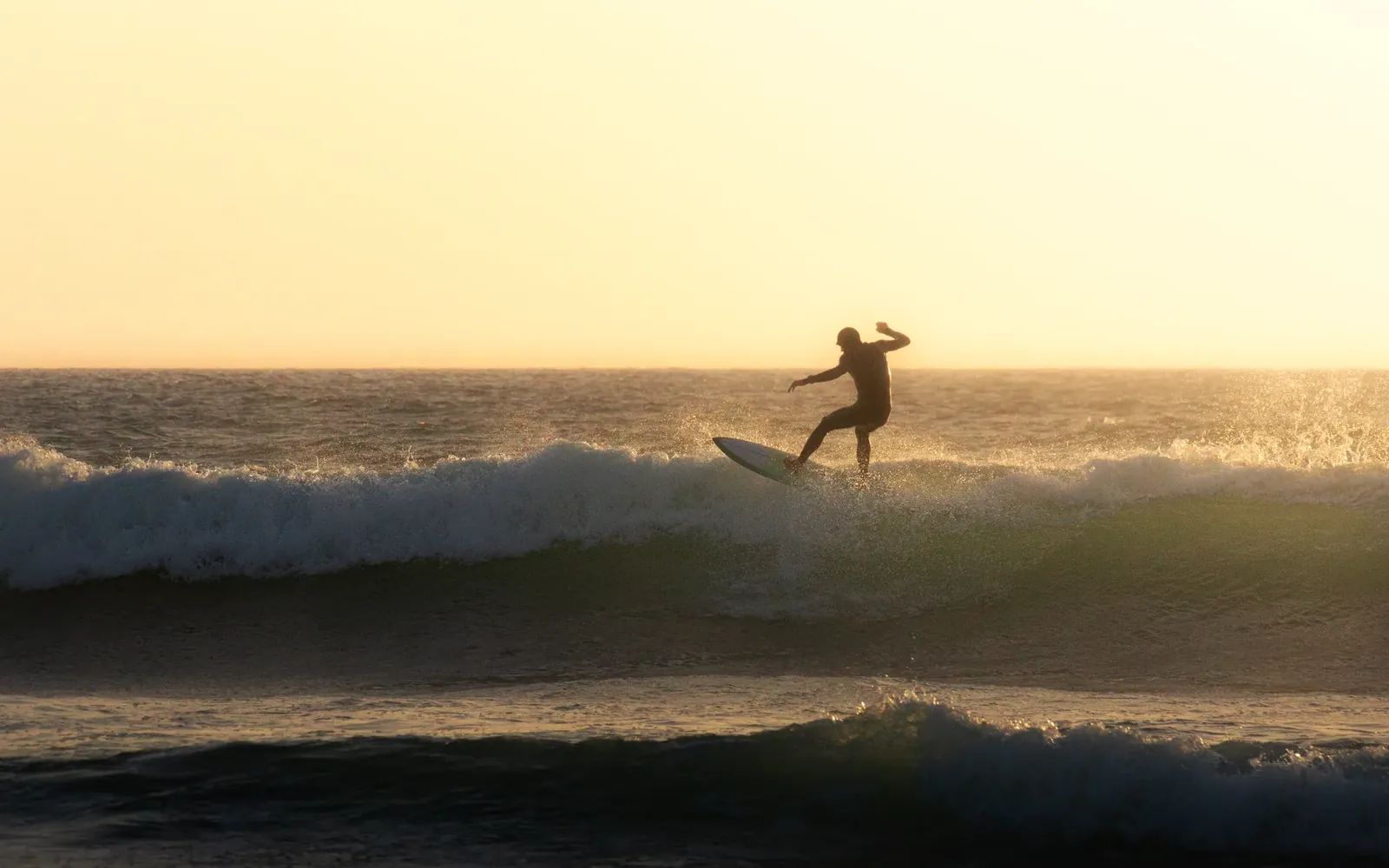 Surfista cogiendo una ola con la pared de agua detrás