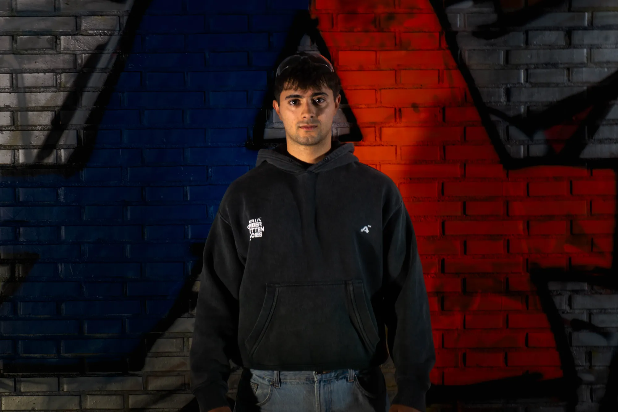 Chico con sudadera de Getaria ante el muro de grafiti con la A
