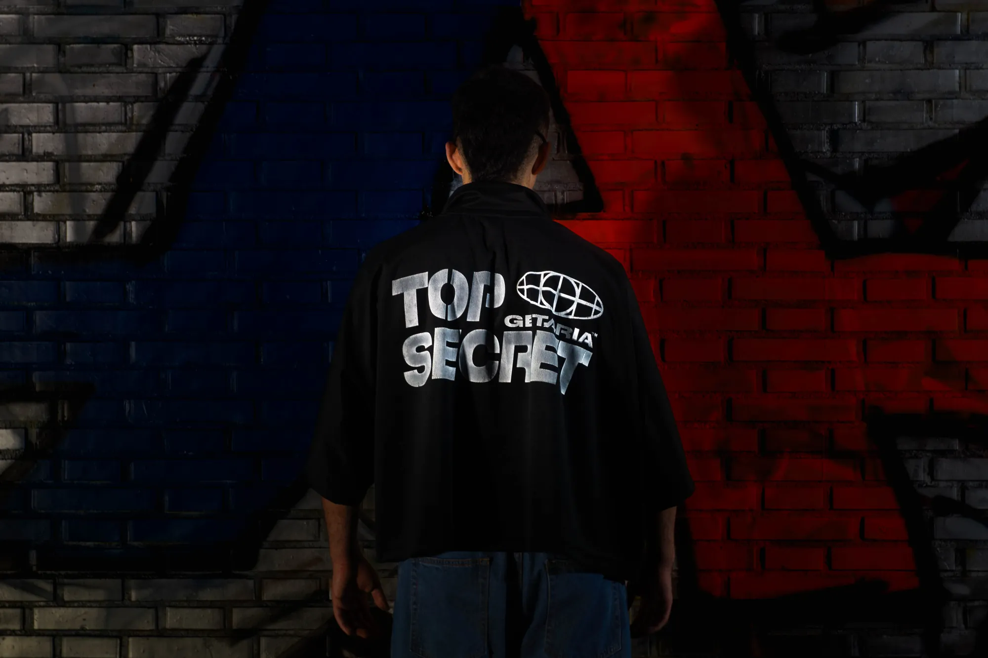 De espaldas, con la camiseta Top Secret
