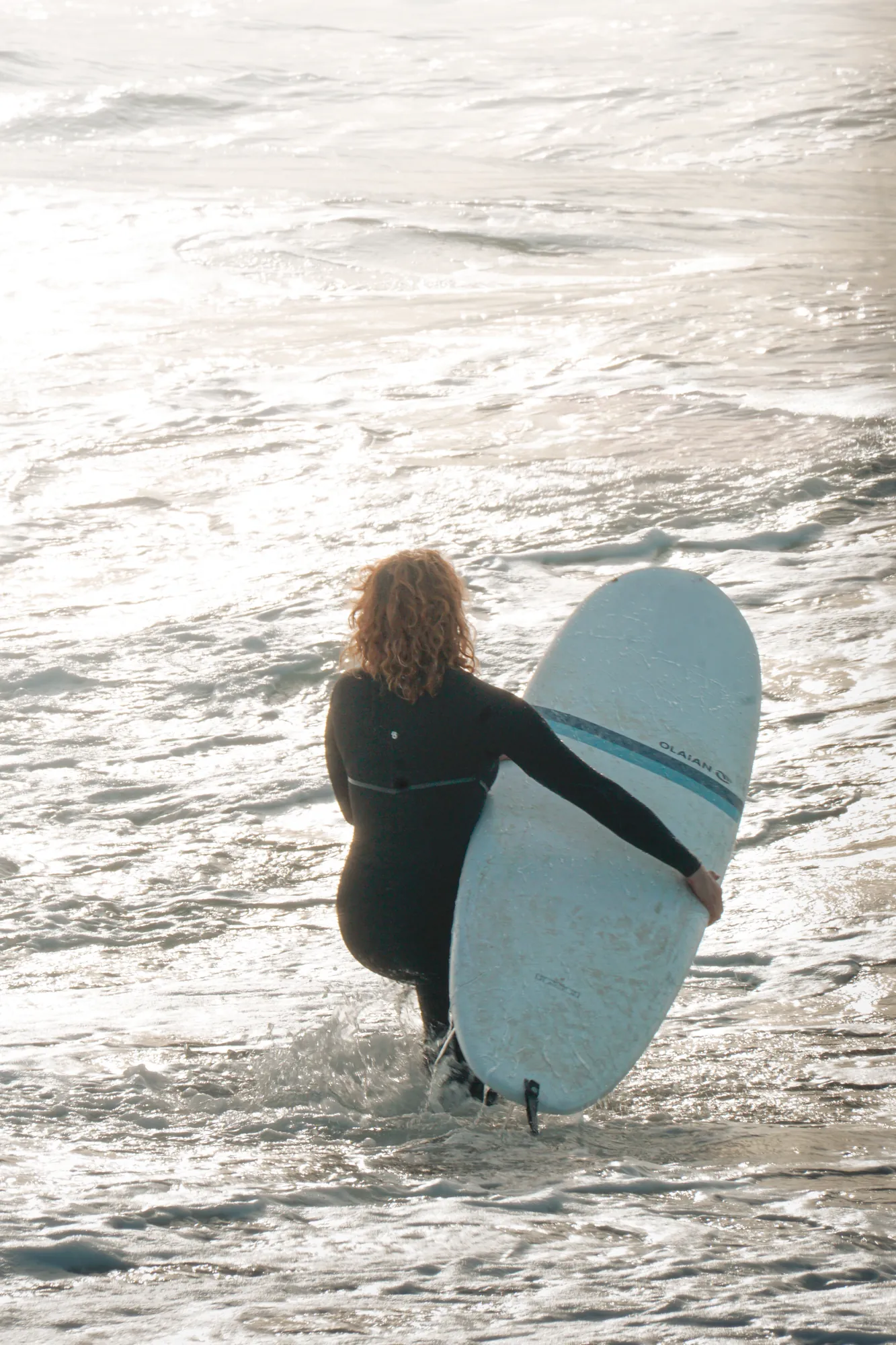 Surfista entrando al agua con la tabla