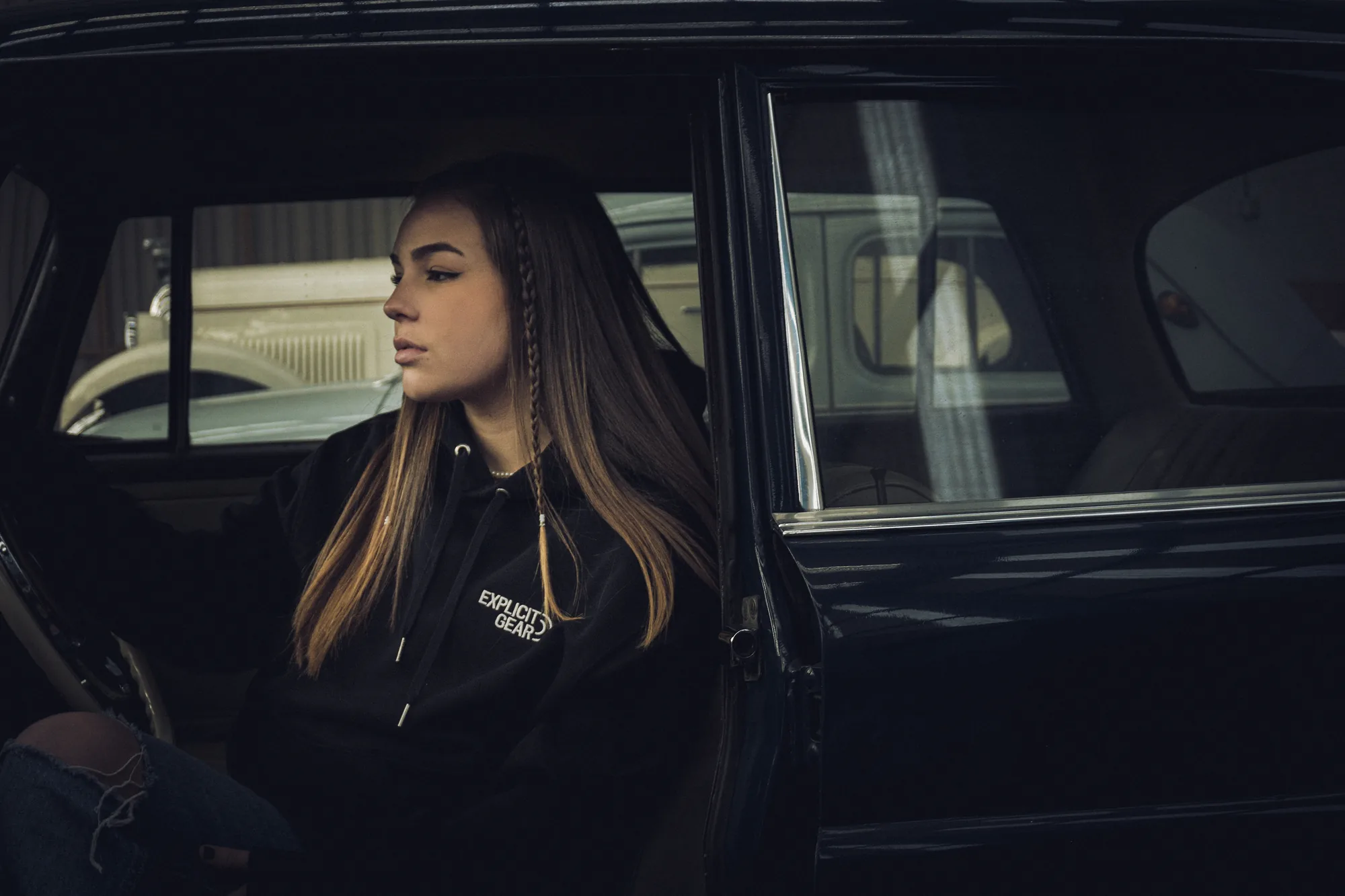 Chica con la sudadera negra de Explicit Gear en el asiento de un coche