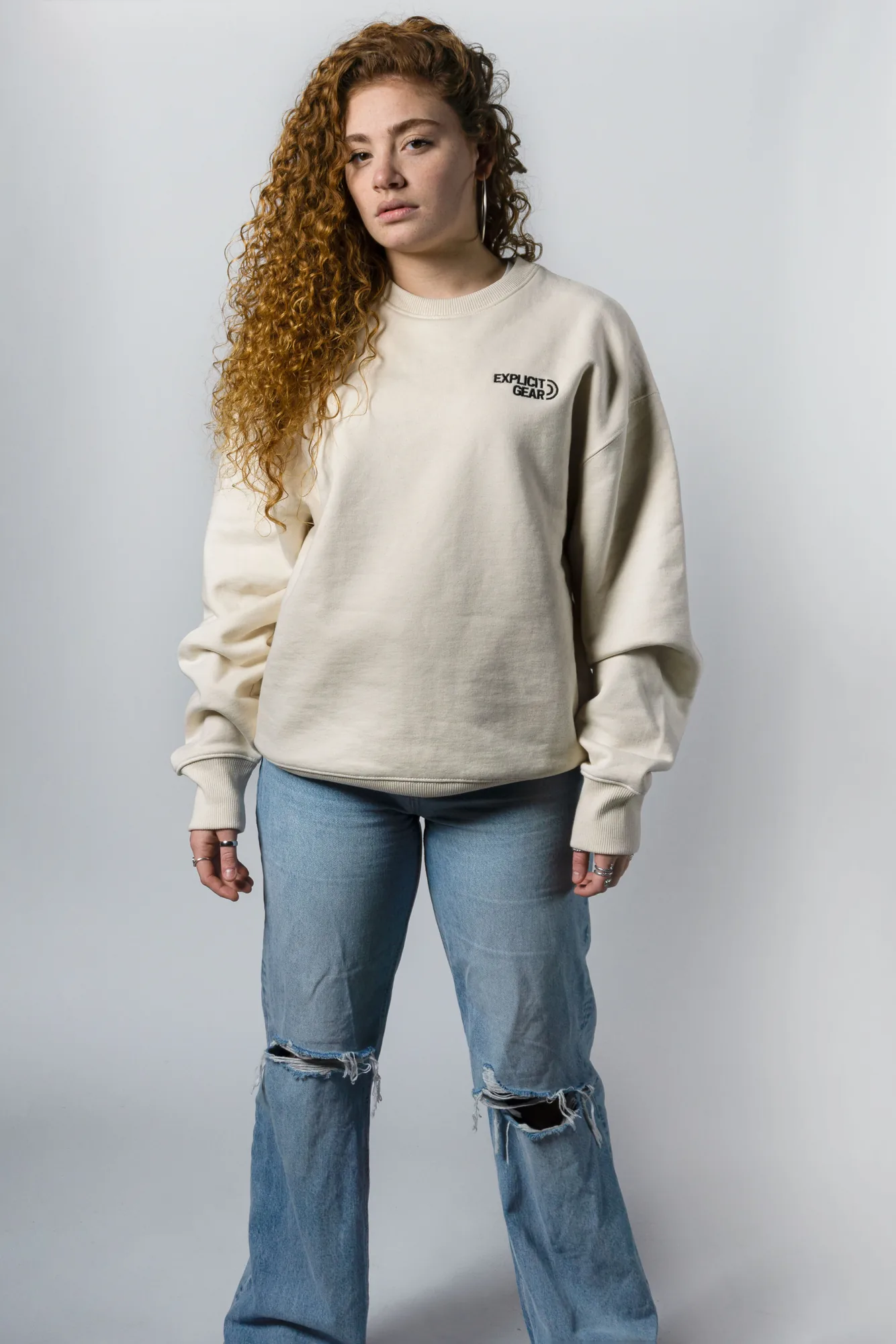 Chica de cuerpo entero con la sudadera crema de Explicit Gear