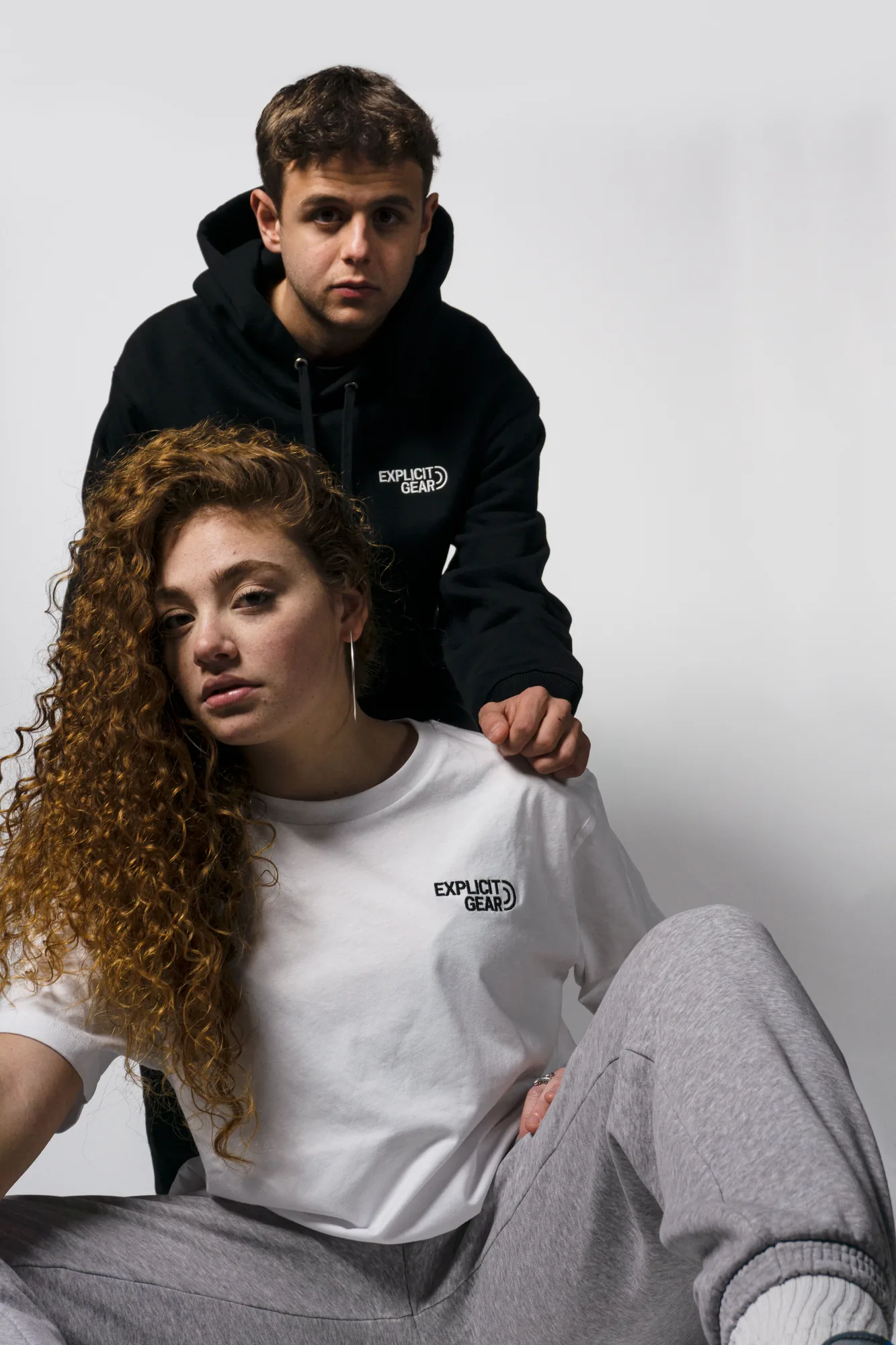 Pareja con sudadera negra y camiseta blanca de Explicit Gear