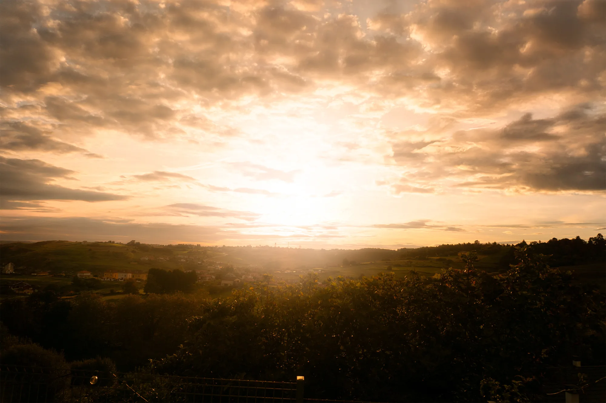 Puesta de sol entre nubes sobre la costa