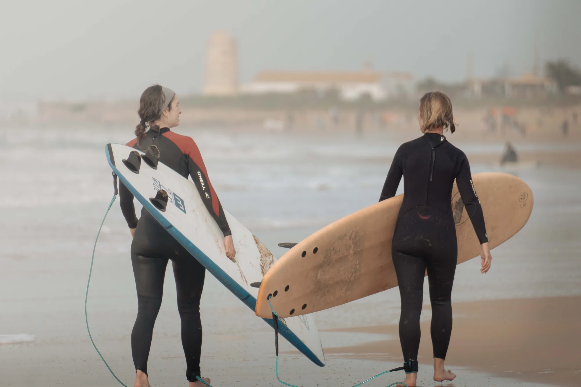 Dos surfistas caminando hacia el mar con sus tablas