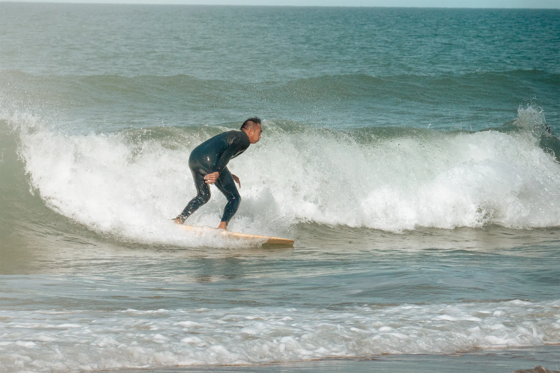 Surfista deslizándose por la pared de una ola