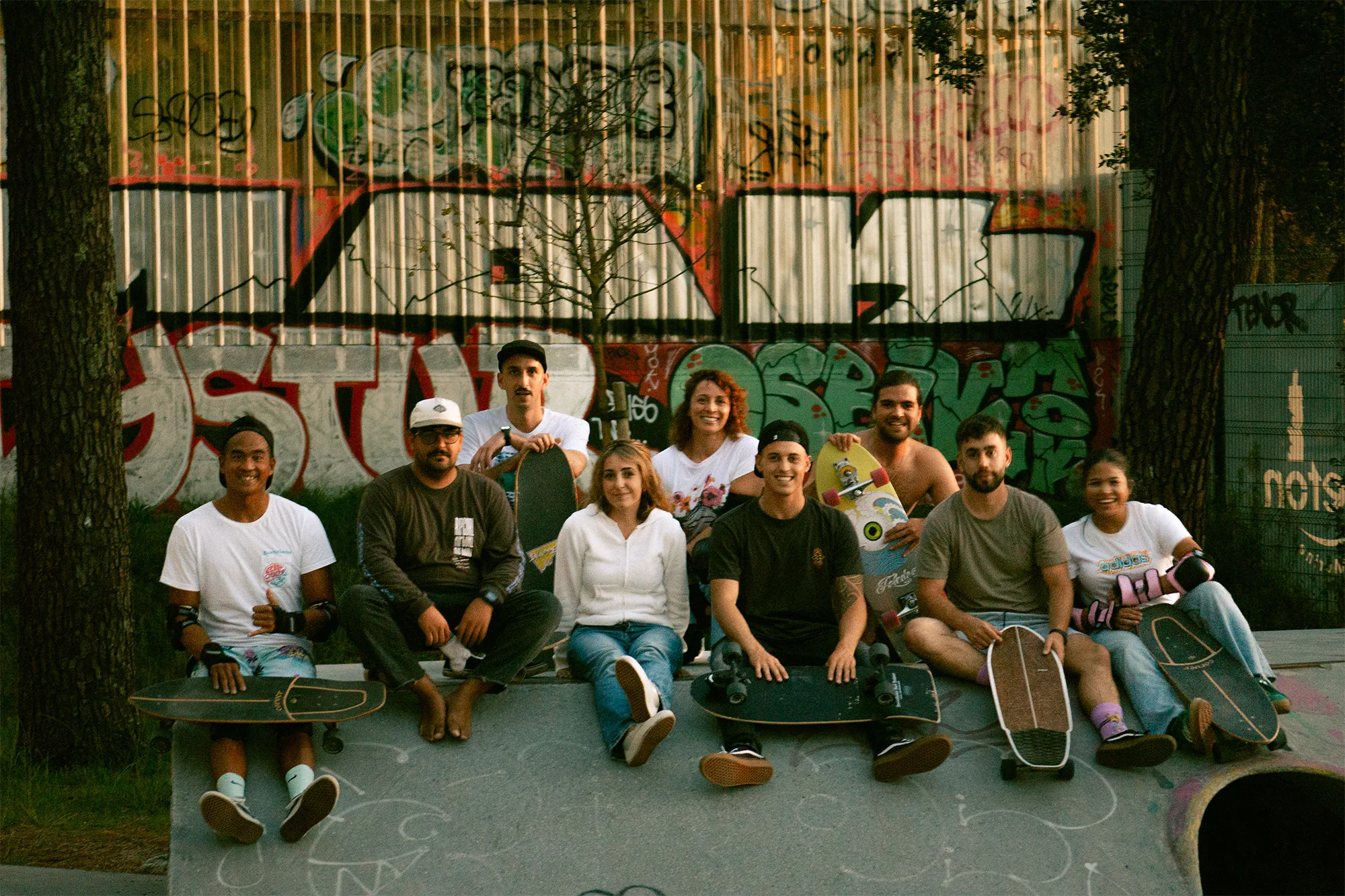 El grupo sentado ante un muro de grafiti