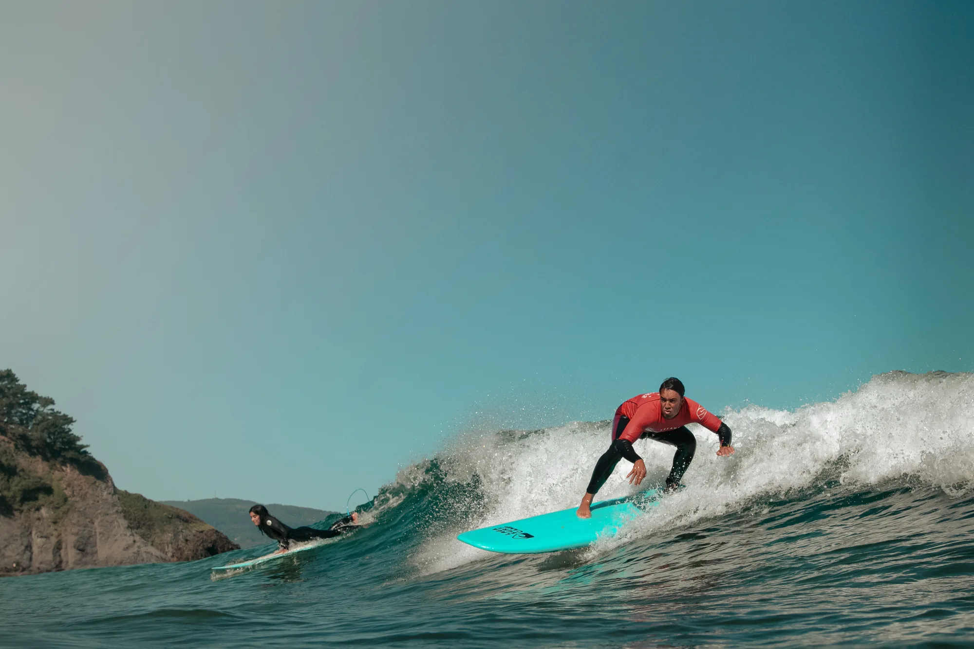 Surfista con licra roja en una ola verde