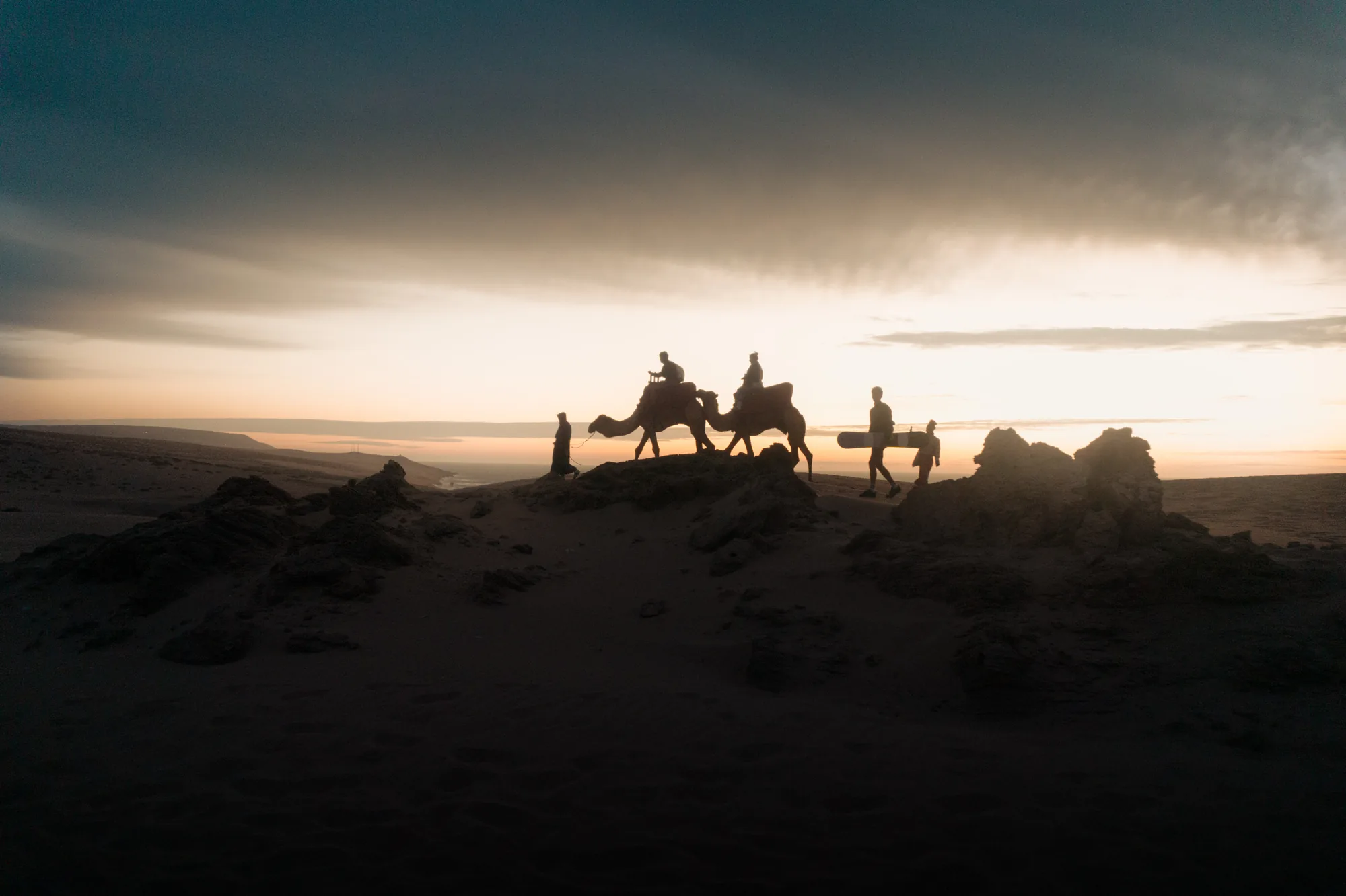 Silueta de una caravana de camellos en las dunas al anochecer