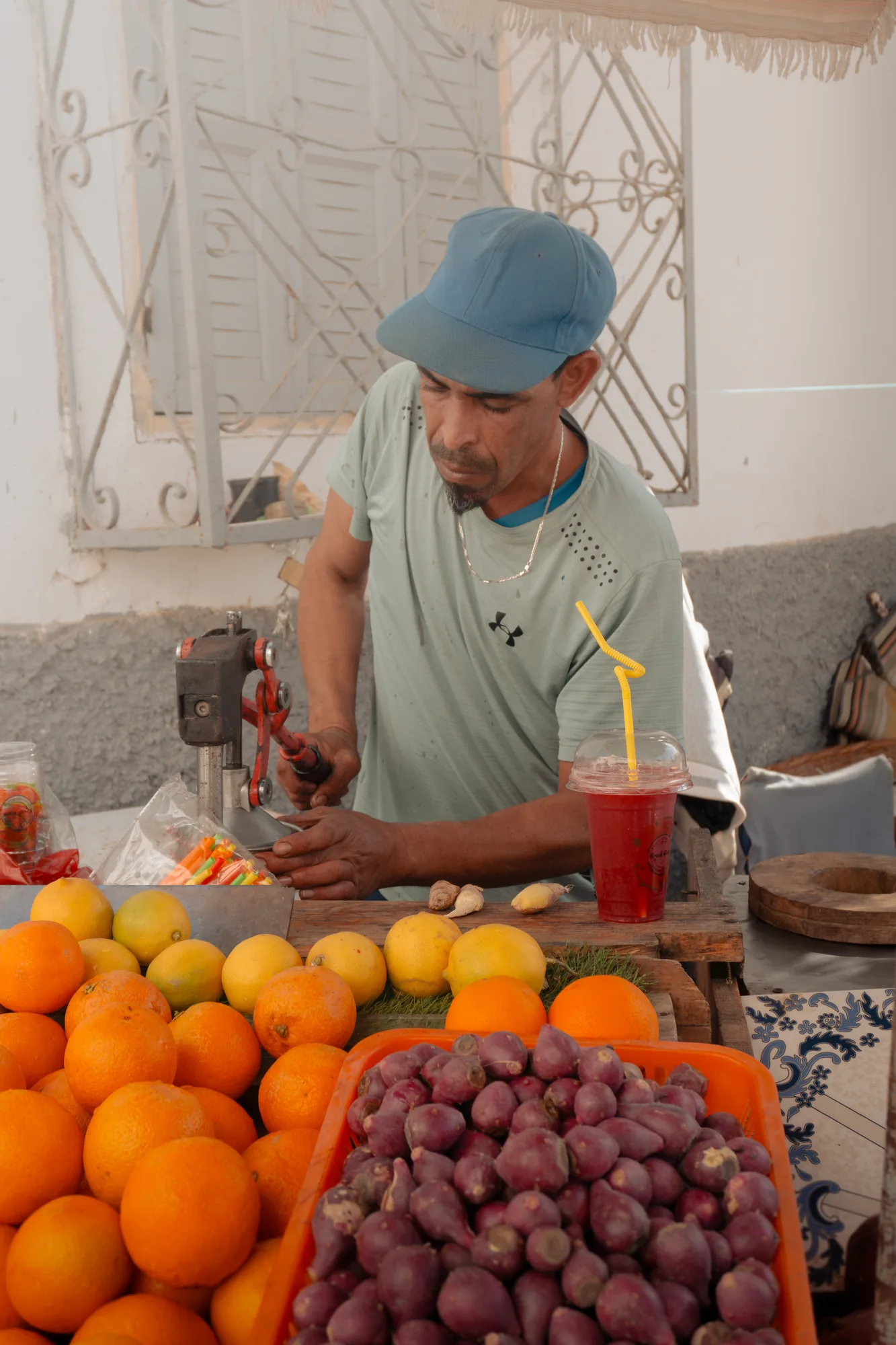 Vendedor de zumos detrás de una montaña de naranjas