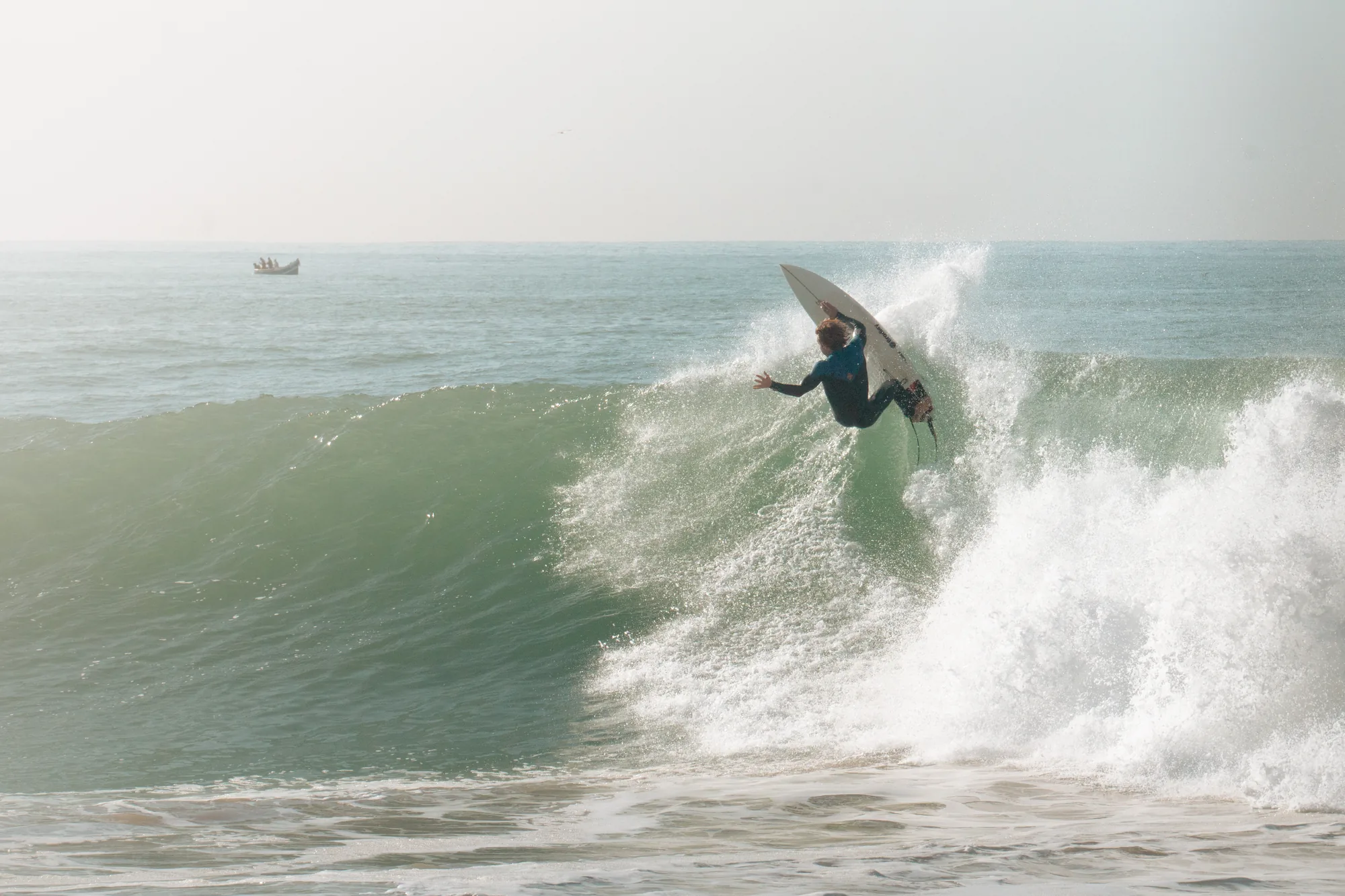 Surfista girando en la cresta de una ola