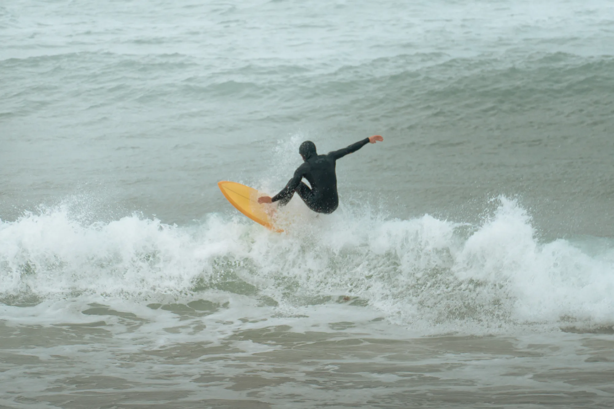 Surfista con tabla amarilla en la espuma