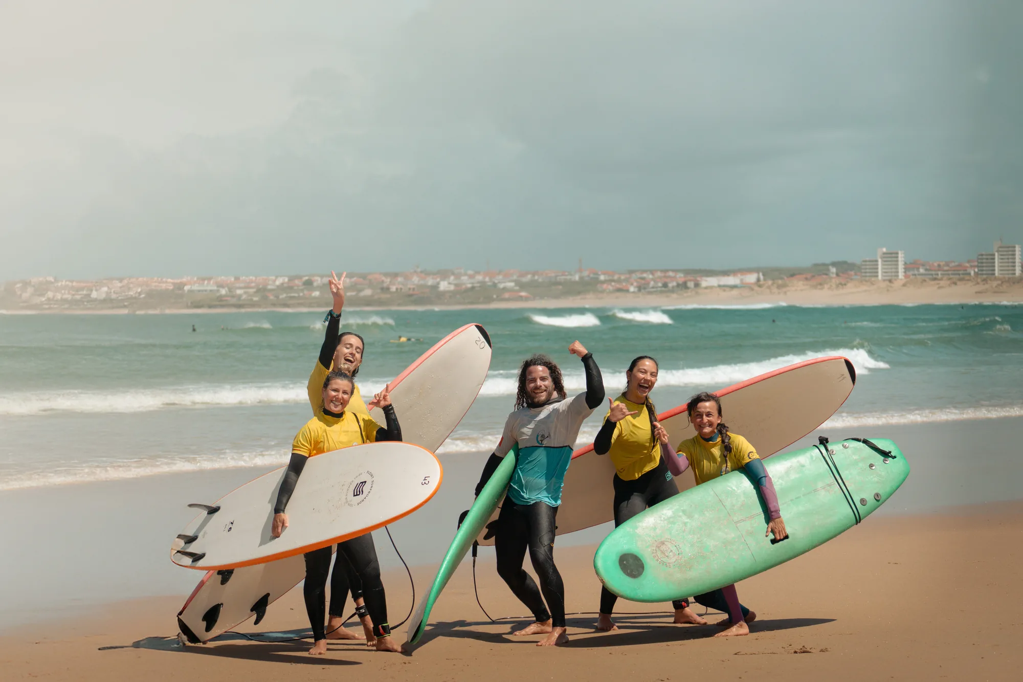 Grupo de surfistas posando con sus tablas en la playa
